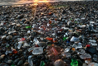 A picture of a large volume of multi-colored sea glass on a beach.