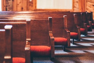 Image description: A row of pews in a church.