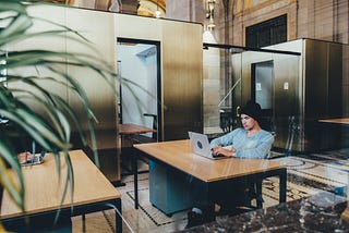 Male sitting in upscale office on laptop