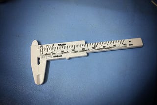 A white plastic Vernier caliper