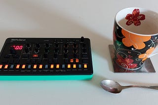 Roland S-1 next to a teacup and teaspoon for scale