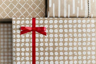 Gift-wrapped spotted package tied with a red ribbon