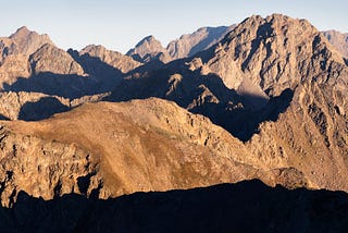 An endless maze of rugged peaks and connecting ridges all bathed in early morning light.