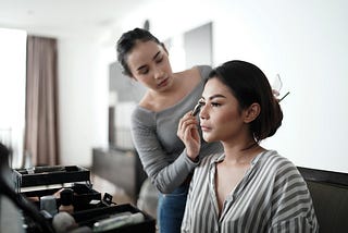 Beautiful woman being made up by her ‘servant’