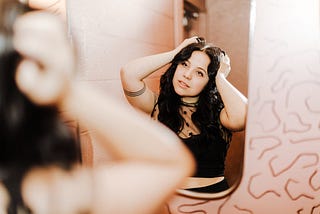 Girl primping herself in front of a mirror
