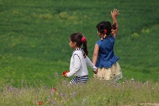 Two young girls waving Goodbye.