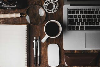 An organized desk containing a coffee mug, a laptop and a notebook along with other small components. It’s used in this article to signify that the topic is mostly work-related.