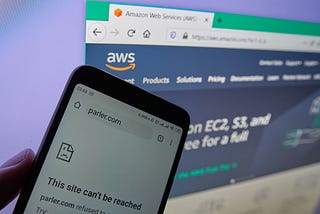 Image showing mobile phone unable to access Parler with AWS website in the background