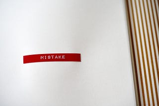 Red sticker with the word mistake on it in white font