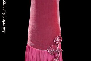 A photograph of an antique pink flapper dress, now preserved in a museum. The date of the dress’s creation is listed as 1925.