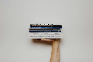 hand holding a stack of books