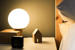 calming bedroom with a soft light table lamp, clean bedside table, and fluffy white linens.