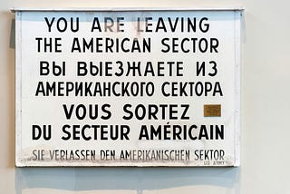 a sign that that has english, russian, and german words on it