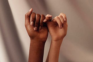 picture of two hands linked by their pinkies