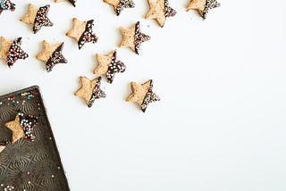 Photo of star cookies with half-dipped chocolate sprinkles on them.