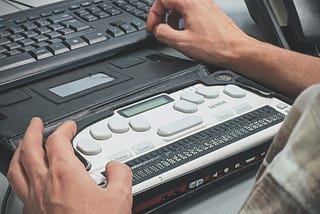 A braille screen reader with the hands of the user in the shot