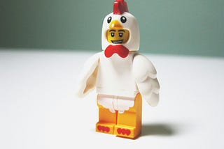 a plastic Lego man in a chicken suit