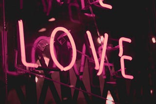 Neon pink sign saying LOVE.