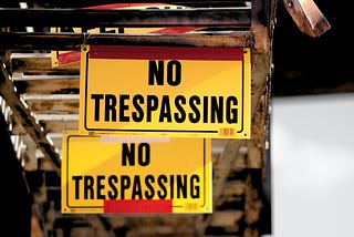 Multiple yellow and black “no trespassing” signs.