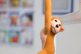 A toy monkey dangles in the frame.