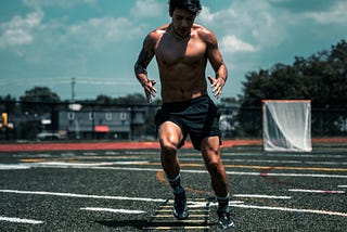 Athlete doing speed and agility drills on a football field.