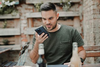 Man holding a phone in his hand to give voice command