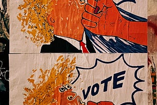 A poster pasted on a wall. It has a cartoon fist punching a caracature of Donald Trump with the word “VOTE” in large letters over it.