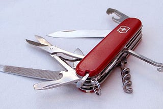 A red Swiss Army Knife with various tools opened