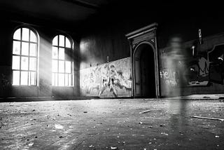 A black-and-white picture of a ghastly figure inside an abandoned building.