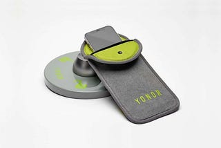 Photo of a Yondr pouch with a phone in it, resting on the tool that staff use to unlock the pouch at the end of the school day