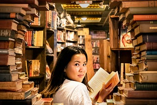 Person looking through a stack of books