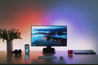 Computer and phone screens glowing in the dark