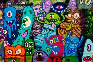 Graffiti art on a brick wall of various colourful monsters.