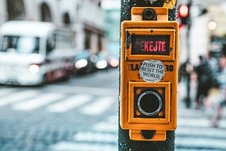 Traffic light with a sticker saying ‘Push to Reset the World’