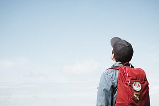 Young man looking up at the blue sky