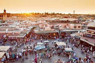 A busy open air market with a lot of people buying and selling