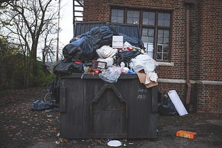 An overflowing dumpster symbolizing all of the trash that we should get rid of in the New Year