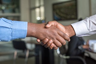 Two people shake hands.