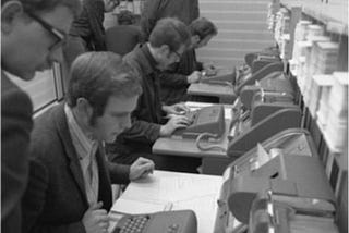Students wearing sport coats typing at keypunch machines