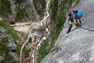 Mountain climber going down a rock face.