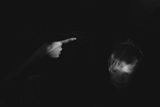 black and white image of a someone waving their finger a crying child