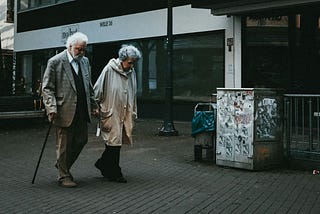 An old couple taking a stride on a lonely street