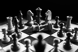 Black and white photo with a chessboard and chess pieces.