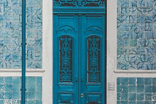 A blue tiled entrance, with blue doors.