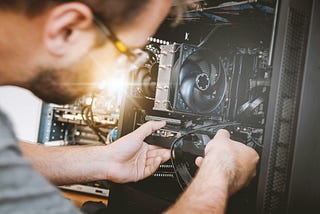 A picture of a technician repairing an elaborate electronic device.