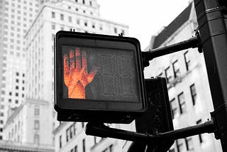 A stoplight with a red hand signal