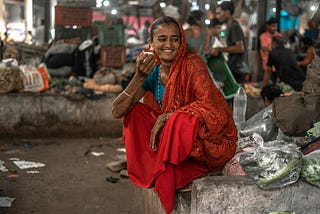 A South Asian woman is all smiles while sipping on chai