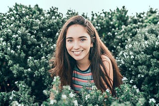 Happy Smiling Girl next to flowers