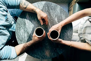 An Interviewer and a Volunteer having an awkward conversation over coffee