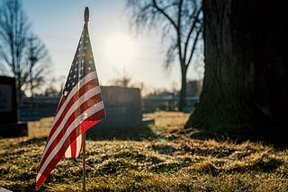 American flag by soldier’s tombstone